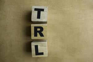 Concept of The wooden Cubes with the word TRL - Technology Readiness Level on wooden background. photo