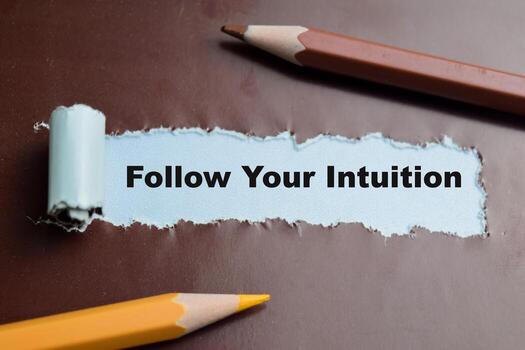 Concept of Follow Your Intuition Text written in torn paper. photo