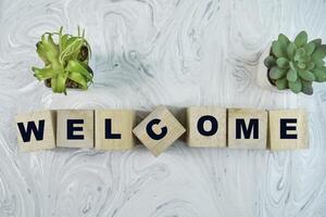 Concept of The wooden Cubes with the word Welcome on wooden background. photo