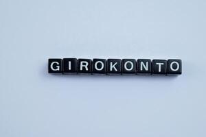 Concept of Girokonto written on wooden blocks. Cross processed image on Wooden Background photo
