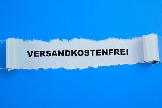 Concept of Versandkostenfrei in Language Germany Text written in torn paper. photo