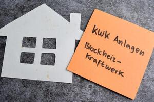 Concept of Kwk Anlagen Blockheizkraftwerk write on sticky notes isolated on Wooden Table. photo