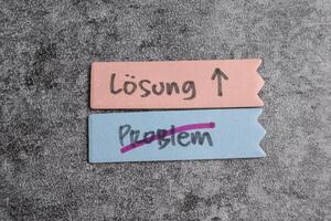 Concept of Losung und Problem write on sticky notes isolated on Wooden Table. photo