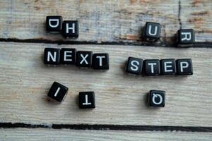 Concept of Next Step written on wooden blocks. Cross processed image on Wooden Background photo