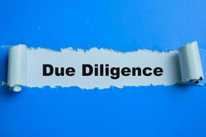 Concept of Due Diligence Text written in torn paper. photo