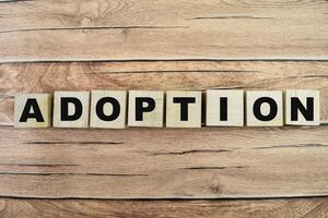 Concept of The wooden Cubes with the word Adoption on wooden background. photo