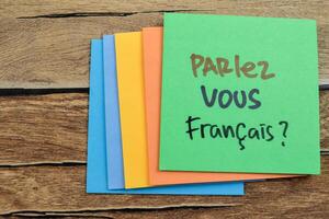 concepto de parlez vous francais en idioma Alemania escribir en pegajoso notas aislado en de madera mesa. foto