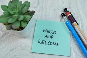 Concept of Hello and Welcome write on sticky notes isolated on Wooden Table. photo