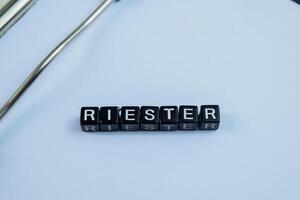 Concept of Riester written on wooden blocks. Cross processed image on Wooden Background photo