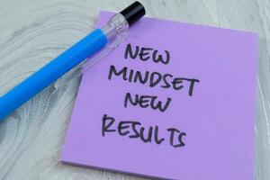 Concept of New Mindset New Results write on sticky notes isolated on Wooden Table. photo