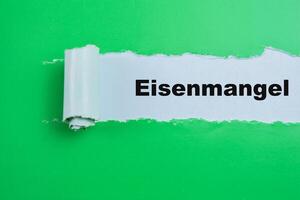 Concept of Eisenmangel in Language Germany Text written in torn paper. photo