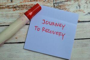 Concept of Journey to Recovery write on sticky notes isolated on Wooden Table. photo