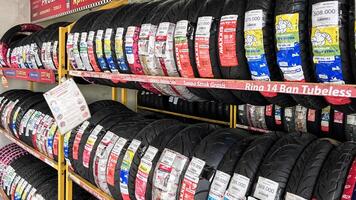 Car tires on rack in auto store, motorcycle transport concept. Bekasi, Indonesia, April 22, 2024 photo