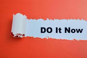 Concept of Do It Now Text written in torn paper. photo