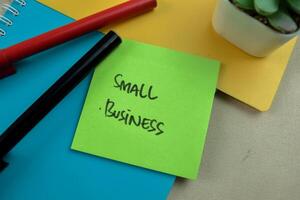 Concept of Small Business write on sticky notes isolated on Wooden Table. photo