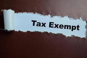 Concept of Tax Exempt Text written in torn paper. photo