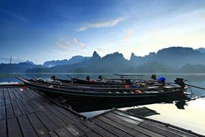 Tropical lakeside hut and wooden boat in Khao Sok national park, Cheow Lan Lake or Ratchaprapha Dam Surat Thani, Thailand photo