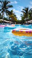 Vertical image of inflatable swimming rings on the blue water of a swimming pool, summer vacation, hotel holiday, swimming pool photo