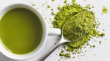 blanco taza con de moda sano matcha verde té hecho desde suelo seco verde té hojas y matcha polvo en un cuchara en un blanco antecedentes foto