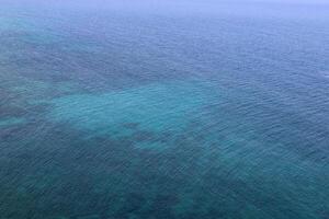 The color of water in the Mediterranean Sea in shallow water. Natural abstract background. photo