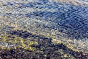 The color of water in the Mediterranean Sea in shallow water. Natural abstract background. photo