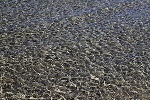 The color of water in the Mediterranean Sea in shallow water. Natural abstract background. photo