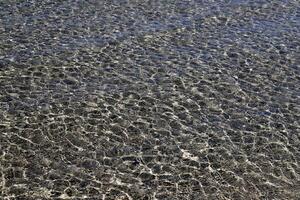 The color of water in the Mediterranean Sea in shallow water. Natural abstract background. photo