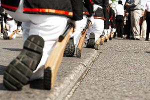 Group of marines wearing military boots and holding a rifle in a patriotic parade. photo