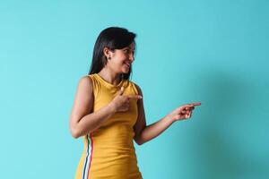 Young happy latinx woman pointing with hands and fingers up to the side. photo