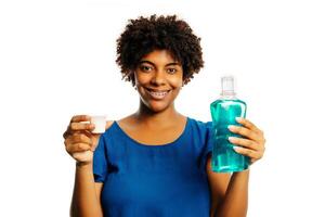 Young hispanic girl holding mouthwash for fresh breath looking at the camera blowing a kiss being lovely and sexy. love expression. photo