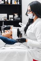 Hispanic cosmetician woman performing a peeling on a young Latin American man. photo