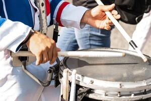 Hands of a person playing a snare with drumsticks. photo