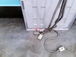 Many AC power distribution or outlets with wire or cable on floor for connecting to machines or lights in industry. Dangerous installed and electrical equipment. photo