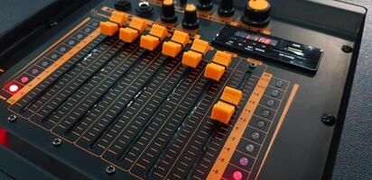 Close up orange button of sound mixer panel equipment for mixing or control audio system with selective focus technique. Technology, Tool and Digital device concept. photo