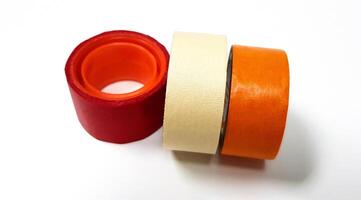 Three masking tapes roll red, white, and orange isolated on white background. Object for stick on paper. photo