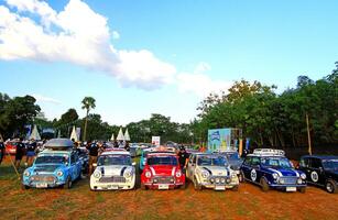 Nakhonratchasima, Thailand - December 26, 2023 Many old Classic Mini Austin Cooper parked on grass field with green tree and clear blue sky background at Khao Yai, Nakhonratchasima, Thailand photo