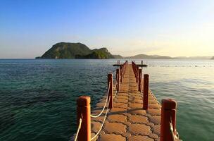 el puente flotadores y estiramientos a el hermosa mar con montaña, azul cielo, nube y puesta de sol ligero. allí es famoso tropical Oceano a krabi, Tailandia foto