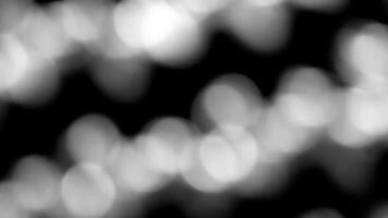 Blurred white Bokeh of light on black background. Lighting blurry wallpaper. photo