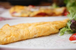 de cerca de llanura huevo tortilla servido con hierbas en un plato foto