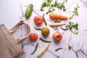 fresh vegetables and fruits with shopping bag on tiles background photo