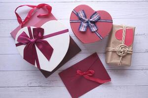 Different colorful gift boxes on wooden background. photo