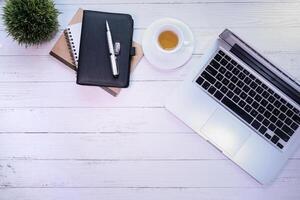 Top view of laptop, tea and notepad with copy space photo