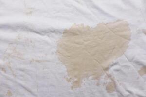 derramado café en blanco camisa de cerca foto
