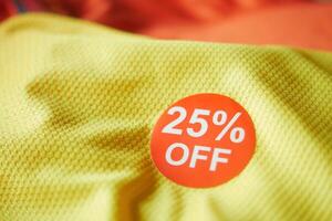 25 discount sakes tag on yellow color cloth photo
