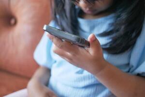 Child girl watching cartoon on smart phone photo