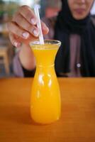 women hand holding a glass of orange juice photo