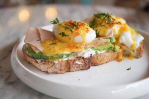 Eggs Benedict with ham on a plate. Delicious breakfast. photo