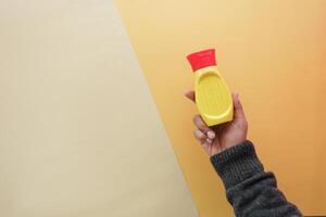 top view of holding a mustard mayonnaise container photo