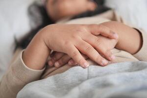 a child sleeping on bed, selective focus on hand photo