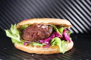 Sandwich with meatballs, lettuce, and red cabbage grilling at home photo